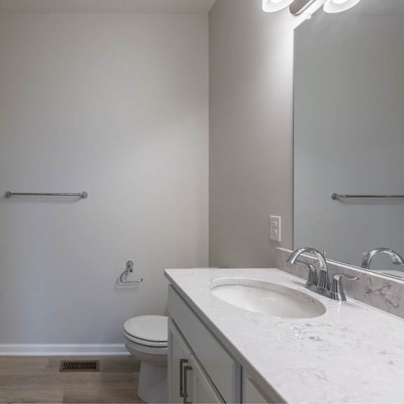 a bathroom with a toilet, sink, and shower.