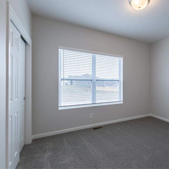 a room with a window and a carpeted floor.