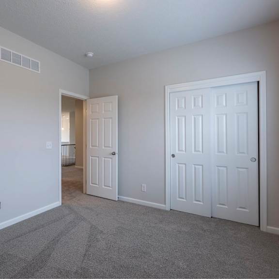 a room with a carpeted floor and two white doors.