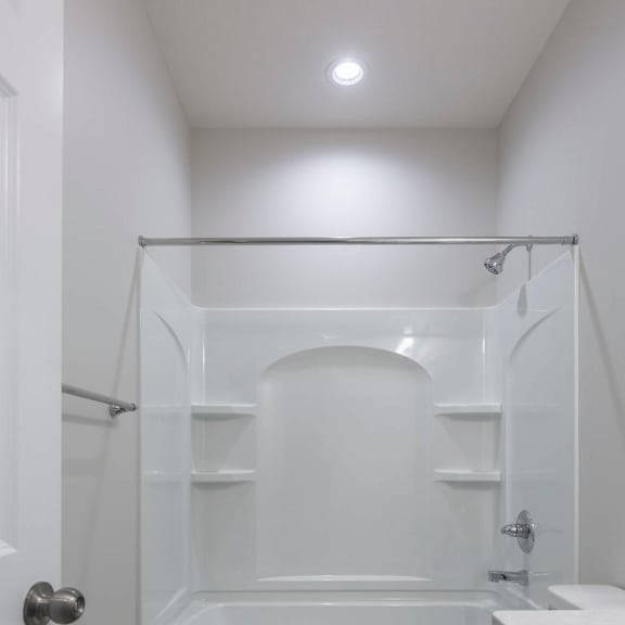 a white bathroom with a toilet, sink, and bathtub.