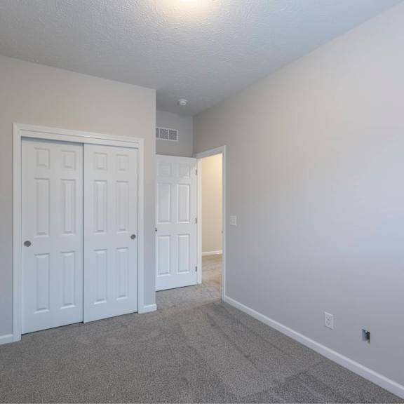 a room with a white door and carpeted floor.