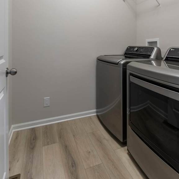 a kitchen with a white door, a wall-mounted oven, and a wall-mounted toaster.