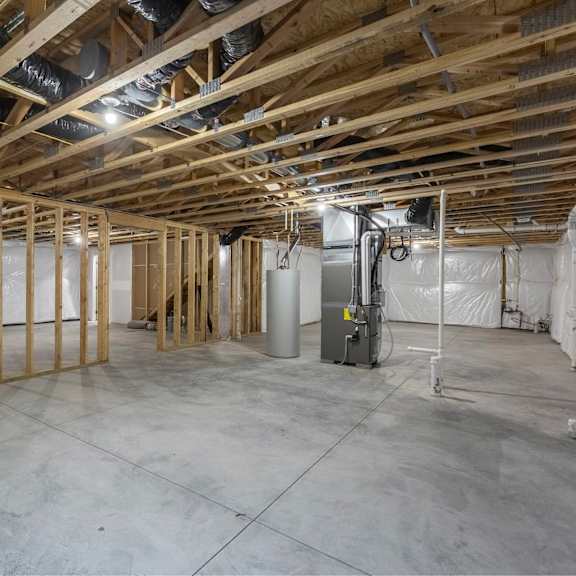 a large, empty room with wooden beams and a concrete floor.