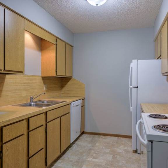 a kitchen with wooden cabinets and a white refrigerator.