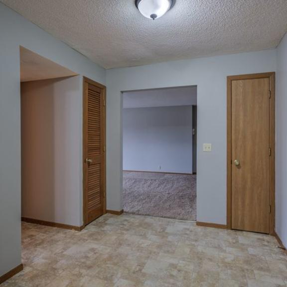 a room with two doors and a carpeted floor.