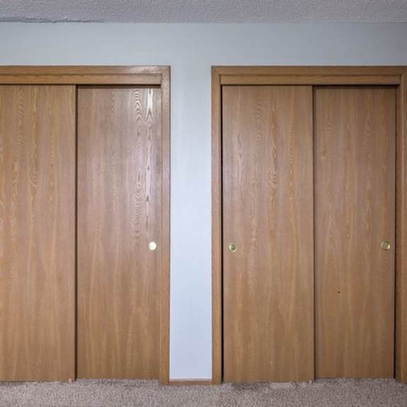 two wooden doors with a white wall in the background.