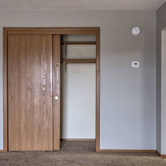 a brown door is open to a white interior.