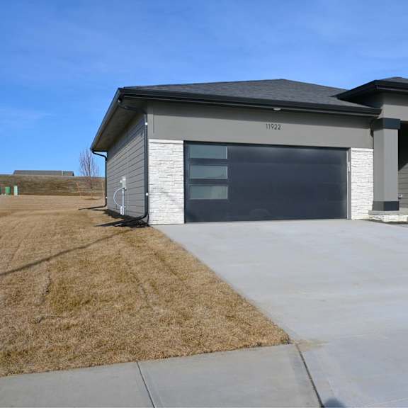 a modern house with a grey exterior and a black roof.