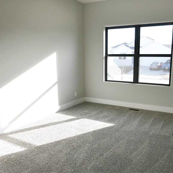 a room with a large window and carpeted floor.