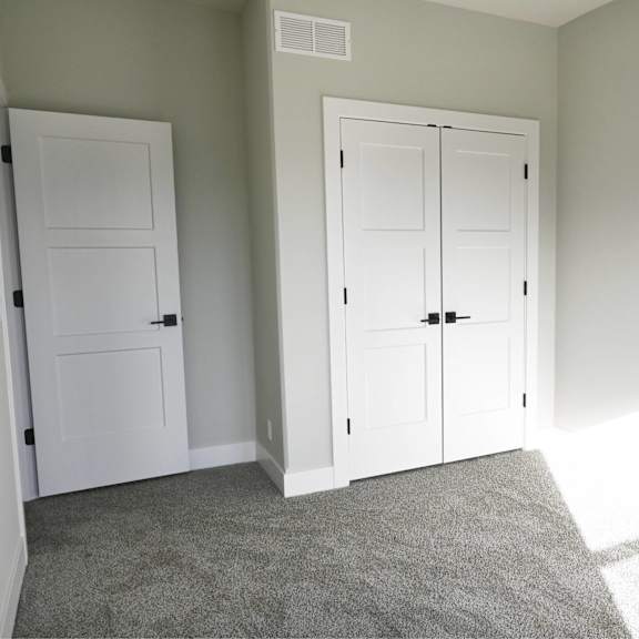 a room with two white doors and a carpeted floor.