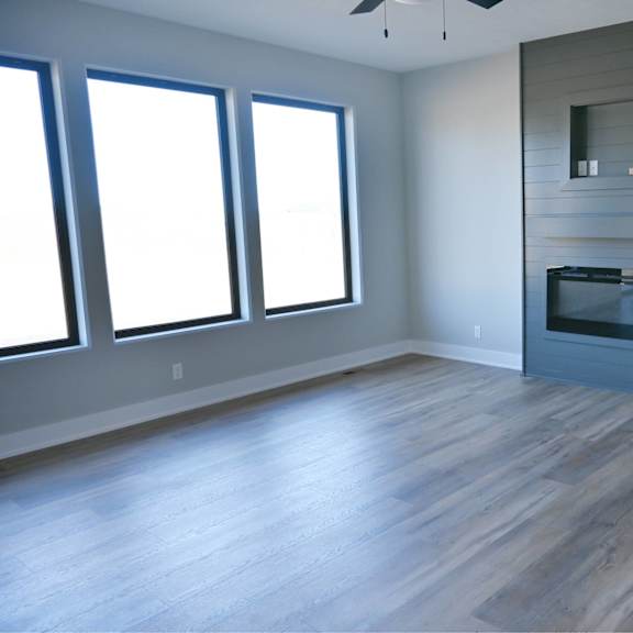 a modern living room with a fireplace and wood flooring.