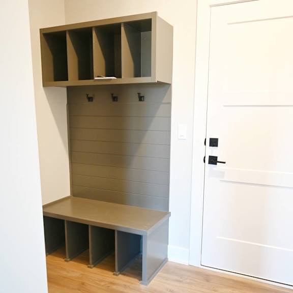 a white door is next to a shelf with several compartments.