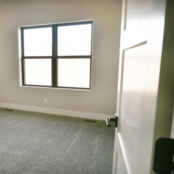 a room with a carpeted floor and a window.