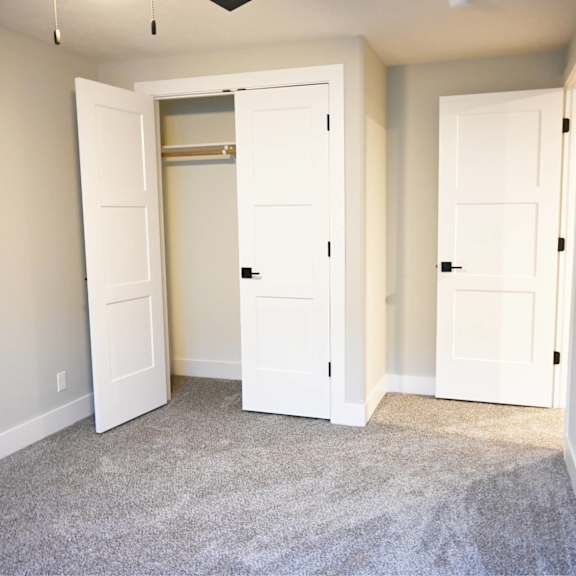 a room with two white doors and a carpeted floor.