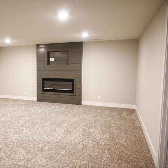 a room with a fireplace and carpeted floor.