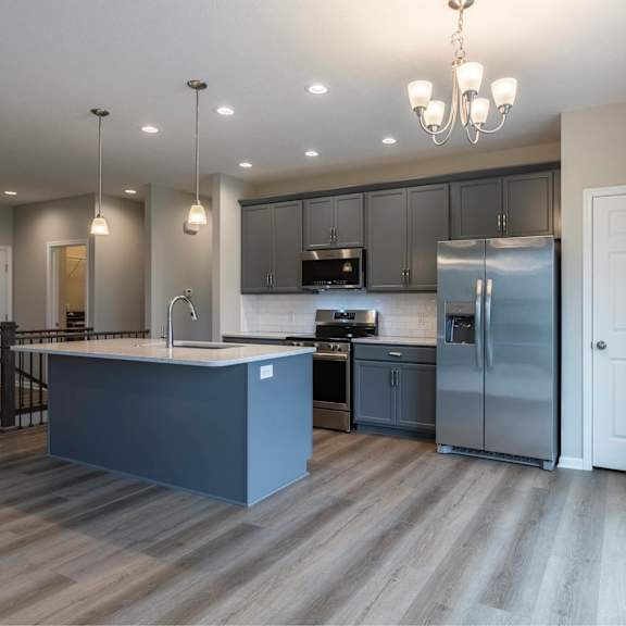 a modern kitchen with a large island and stainless steel appliances.
