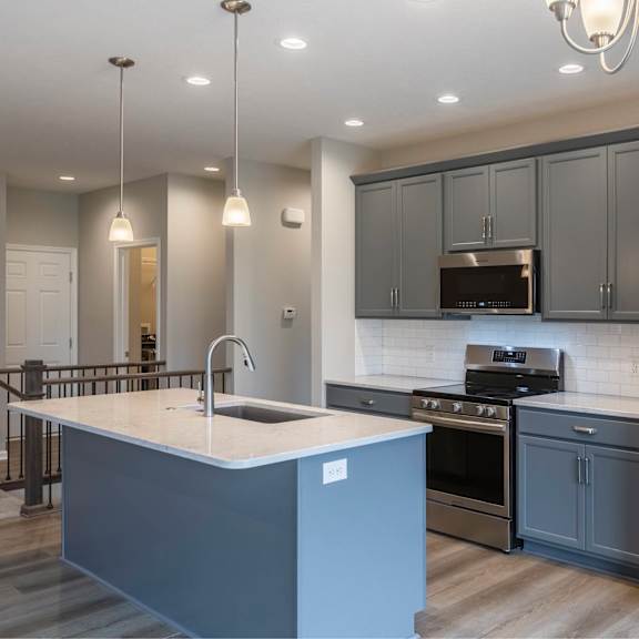 a modern kitchen with a large island and stainless steel appliances.
