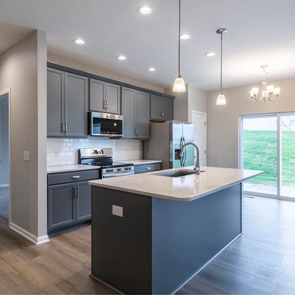 a modern kitchen with dark wood floors and a large island.