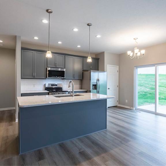 a modern kitchen with a large island and a view of the backyard.