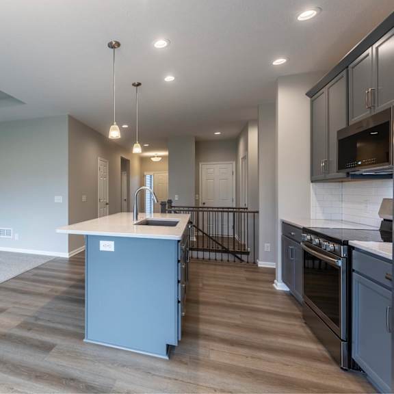 a modern kitchen with a large island and stainless steel appliances.