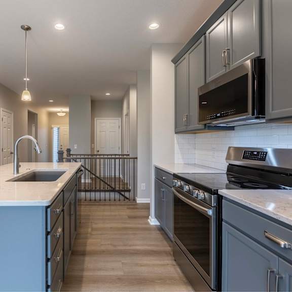 a modern kitchen with a sink, stove, and cabinets.