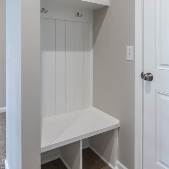 a white built in bench and shelves in a room.
