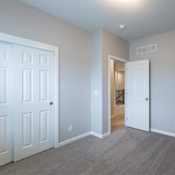 a room with a white door and a grey carpet.