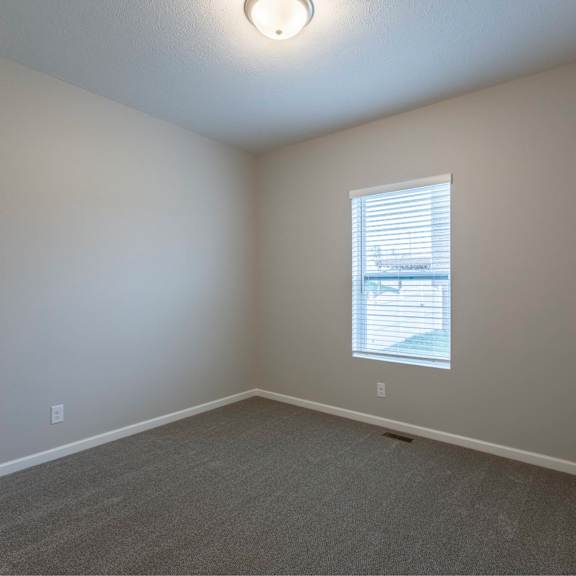 a room with a window and carpeted floor.