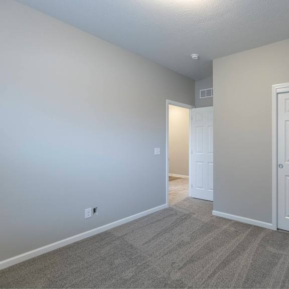 a room with a carpeted floor and a white door.