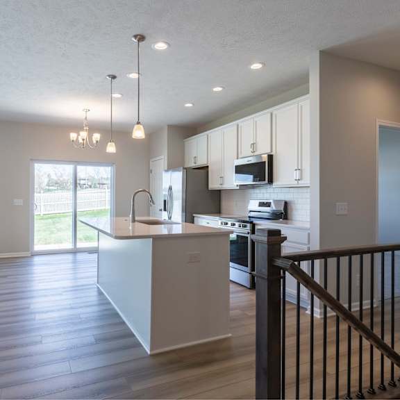 a modern kitchen with a white island and stainless steel appliances.