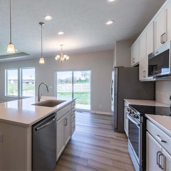 a modern kitchen with a stone fireplace and stainless steel appliances.