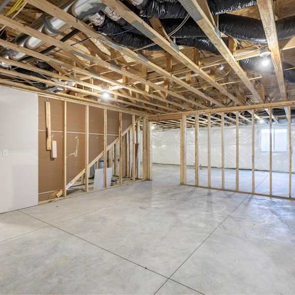 a room under construction with exposed wooden beams and unfinished walls.