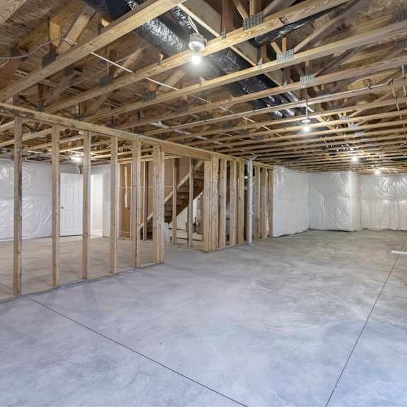 a spacious unfinished room with wooden beams and insulation on the walls.