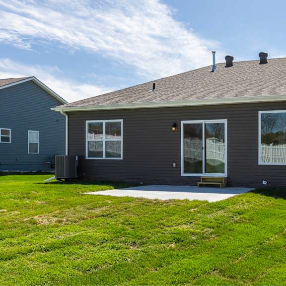 a grey house with a green lawn in front.