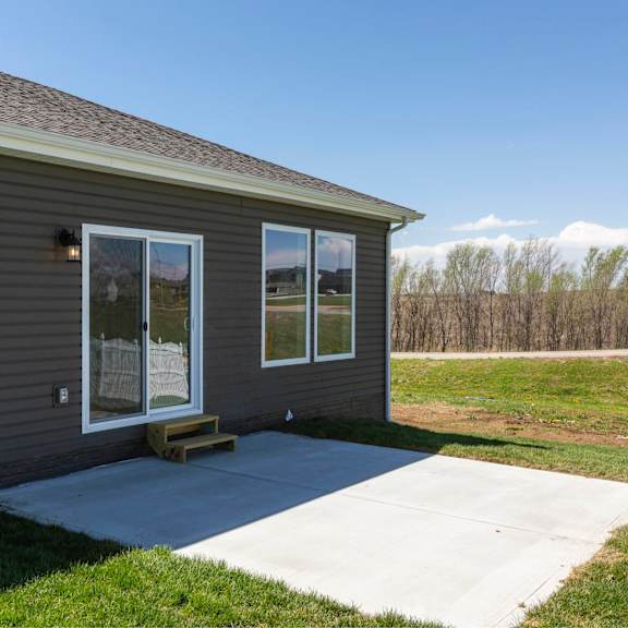 a house with a grey siding and a white door.