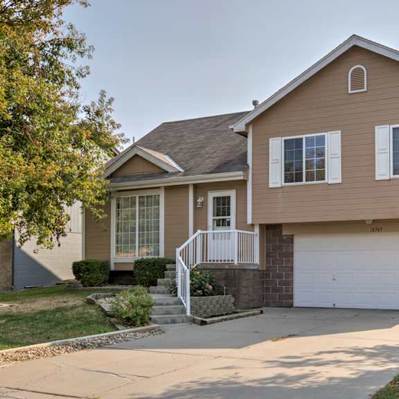 a house with a brown exterior and a white garage door.