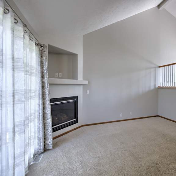 a living room with a fireplace and carpeted floor.