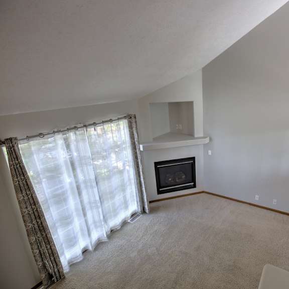 a living room with a fireplace and a staircase.