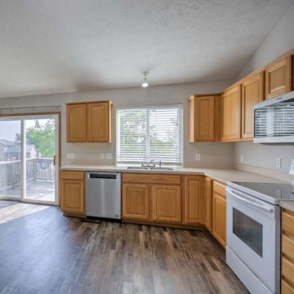 a kitchen with wooden cabinets and a fan on the ceiling.