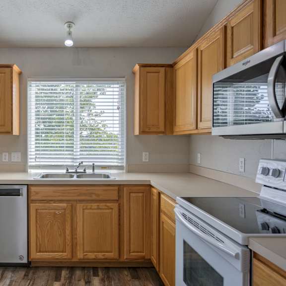 a kitchen with wooden cabinets and stainless steel appliances.