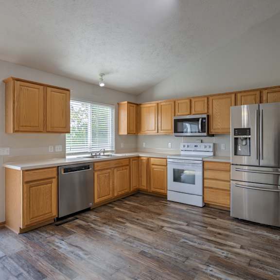 a kitchen with wooden cabinets and stainless steel appliances.