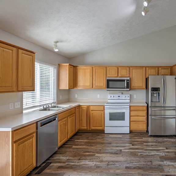 a kitchen with wooden cabinets and a white stove top oven.