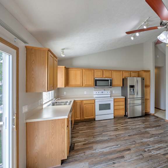 a kitchen with wooden cabinets and a white counter top.