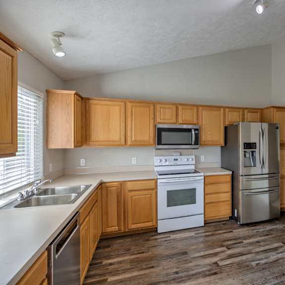 a kitchen with wooden cabinets and a stainless steel refrigerator.