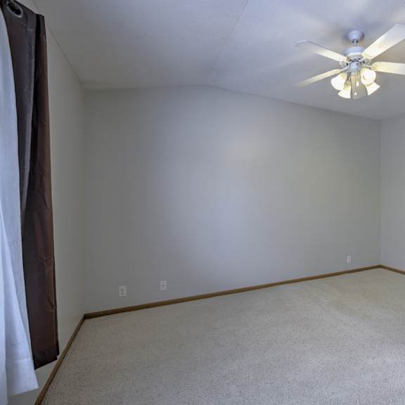 empty room with a ceiling fan and carpeted floor.