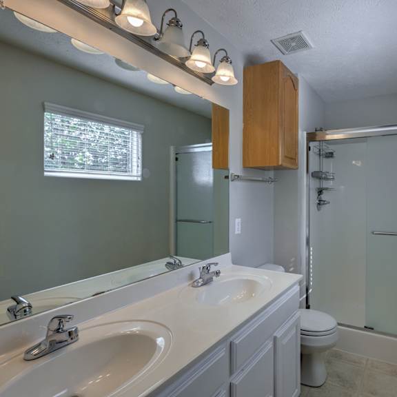 a bathroom with a white sink and a glass shower door.