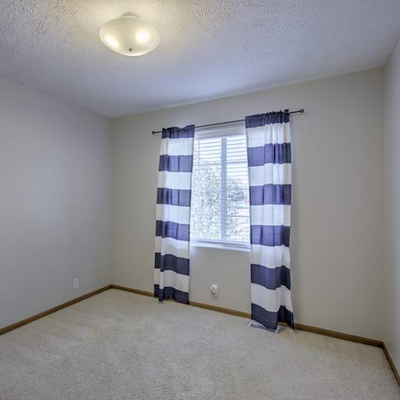 a room with a window covered by a striped curtain.