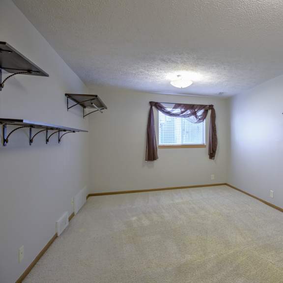 a room with a window and a carpeted floor.