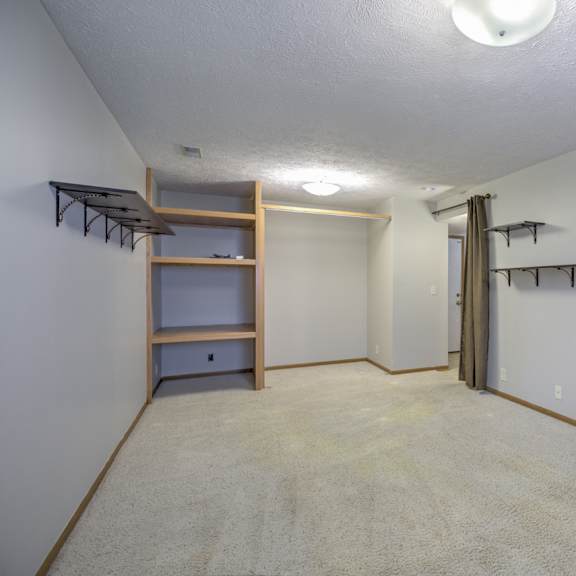 a large, empty room with a carpeted floor and a ceiling light.