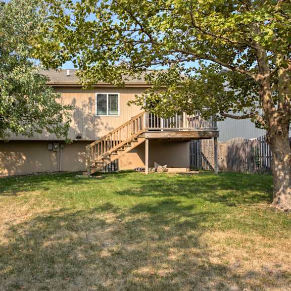 a house with a brown roof and a tree in front of it.